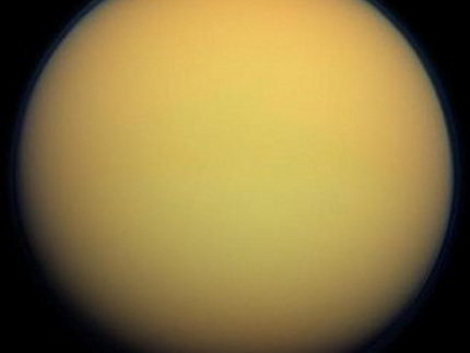 Titan in natural color. The thick atmosphere is orange due to a dense organonitrogen haze.
