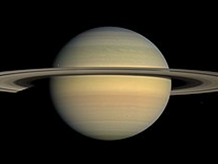 Saturn: Pictured in natural color approaching equinox, photographed by Cassini in July 2008; the dot in the bottom left corner is Titan.